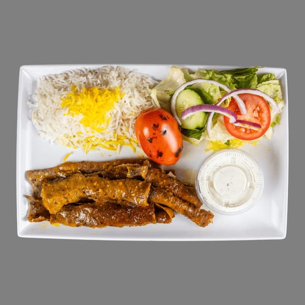 ZK Grill's Mediterranean plate with rice, grilled meat, salad, a roasted tomato, and sauce.