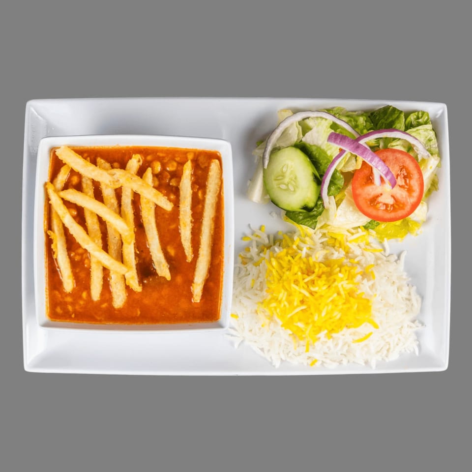 A Mediterranean dish with stew and fries, rice with saffron, and a side salad.