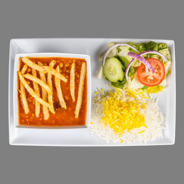 A Mediterranean dish with stew and fries, rice, and a side salad on a white rectangular plate.