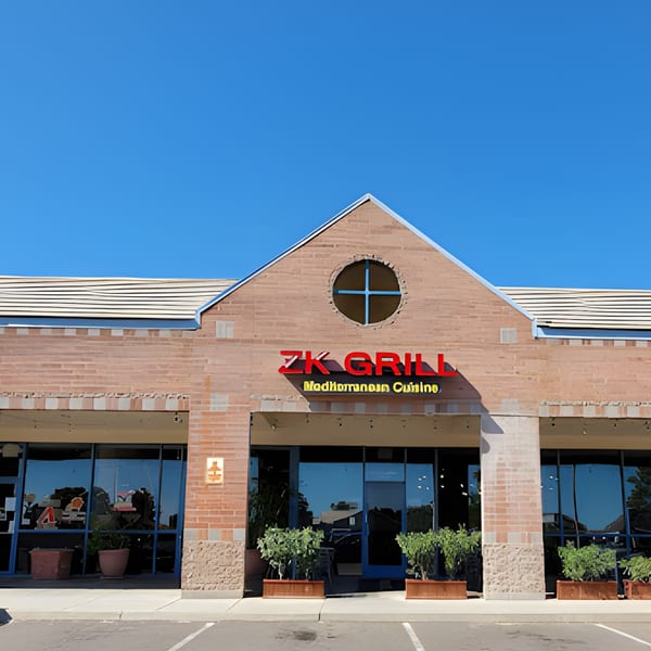 Exterior of ZK Grill, a Mediterranean restaurant with a brick facade and large windows.